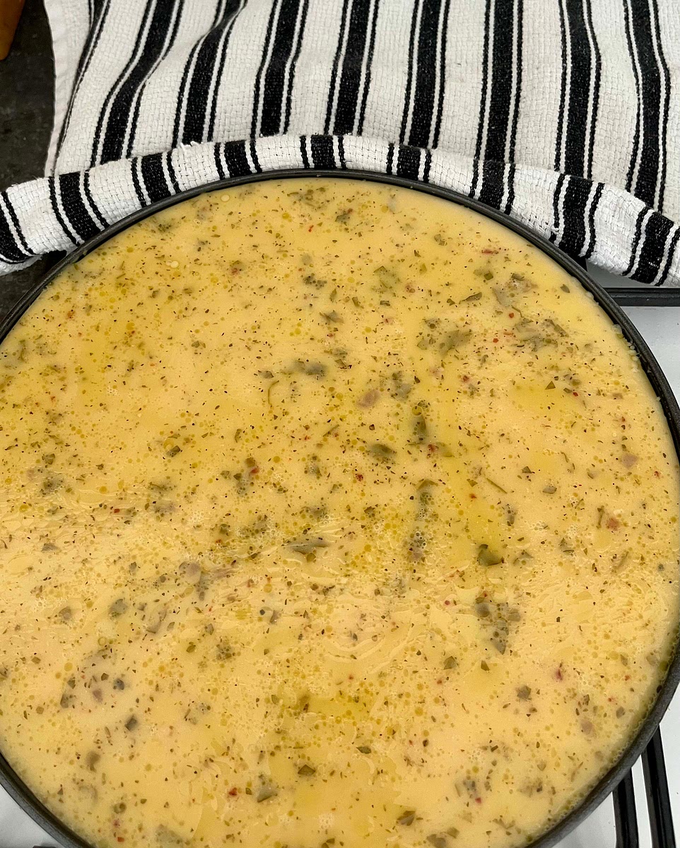 Take the pizza pan out of the oven and carefully pour in the batter.