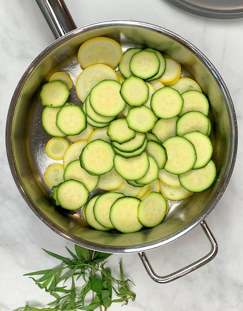Heat oil in a deep skillet, add slices of summer squash and zucchini and cook for about 5-7 minutes until softened.