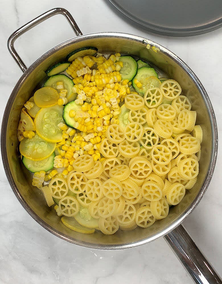 Add garlic, white wine, corn kernels, cooked pasta, salt & pepper, grated Parmigiano Reggiano cheese.