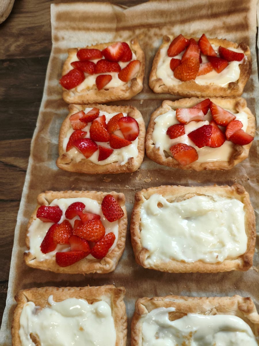 Erdbeeren auf dem Pudding verteilen. Tortenguss nach Packungsanweisung kochen und über den Erdbeer-Pudding-Schiffen verteilen.