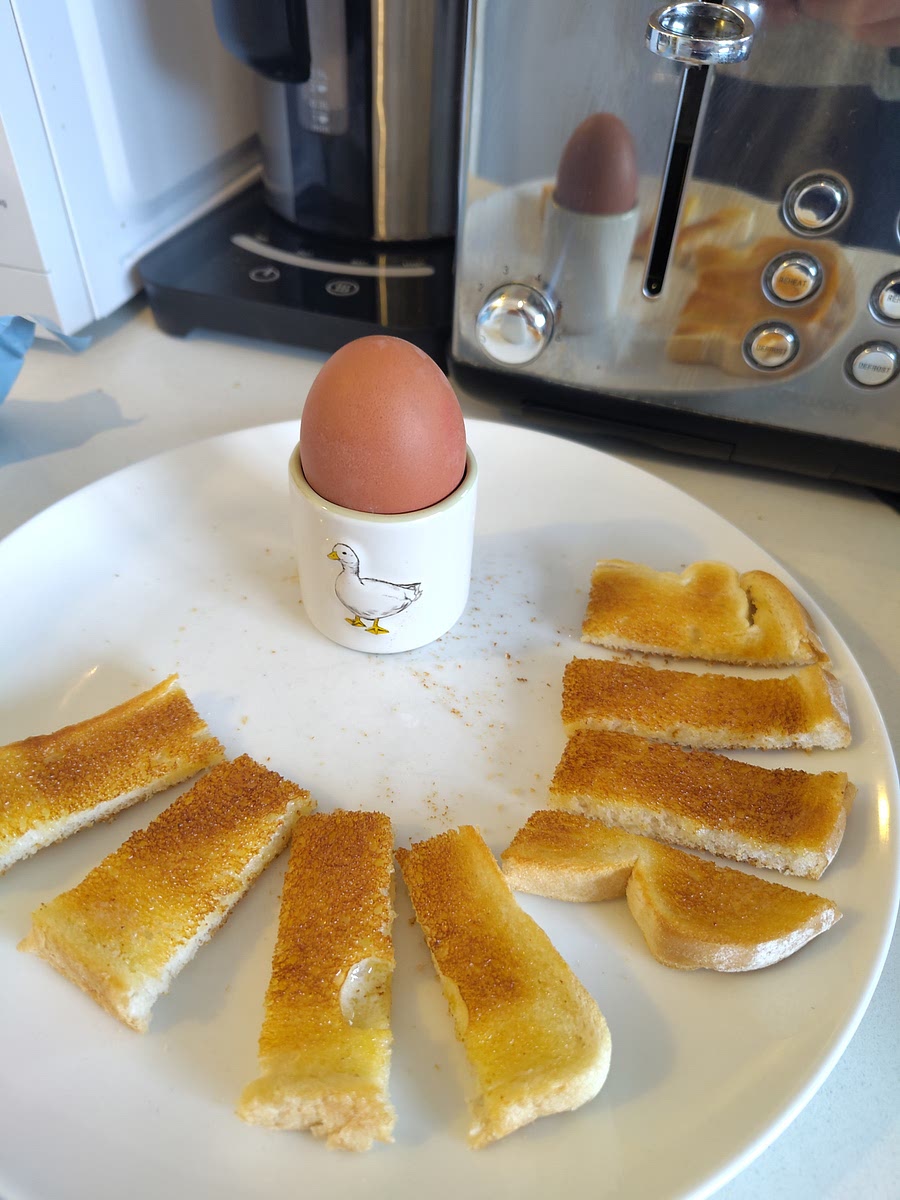 Place eggs in cup and cut off the top. Serve with the bread.