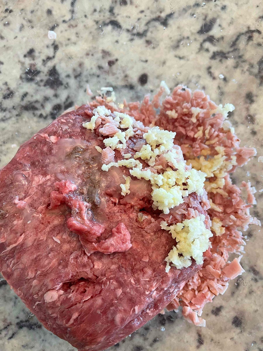 Use a garlic press to press garlic into the bowl.