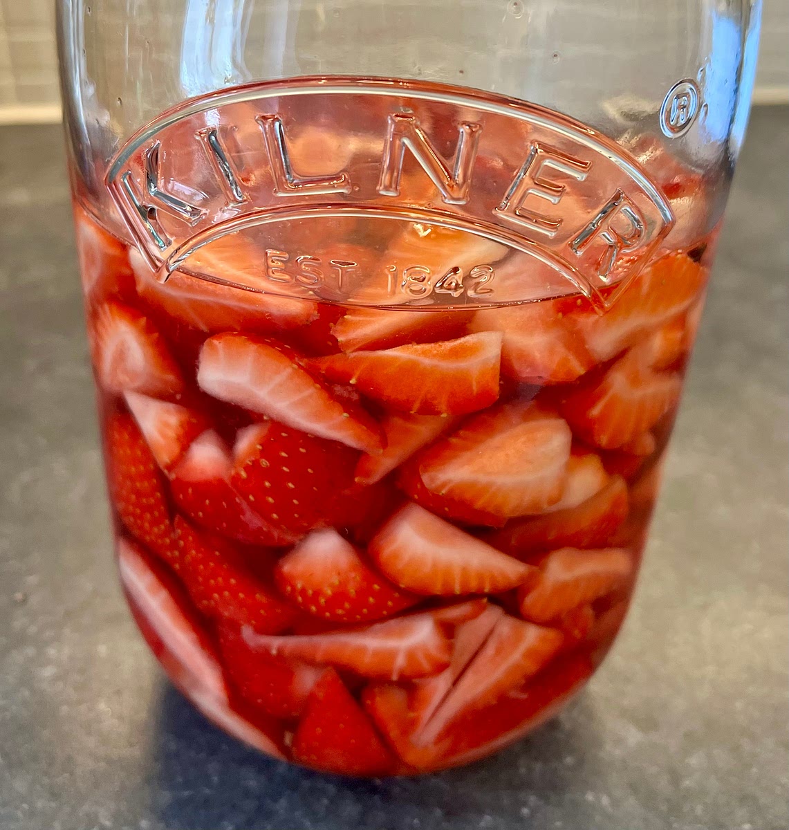 As you cut the strawberries, add the wedges to the jar. Once all are in, give the jar a quick shake and place it in a dark cool place for 40 days. Give it a quick shake once a week.