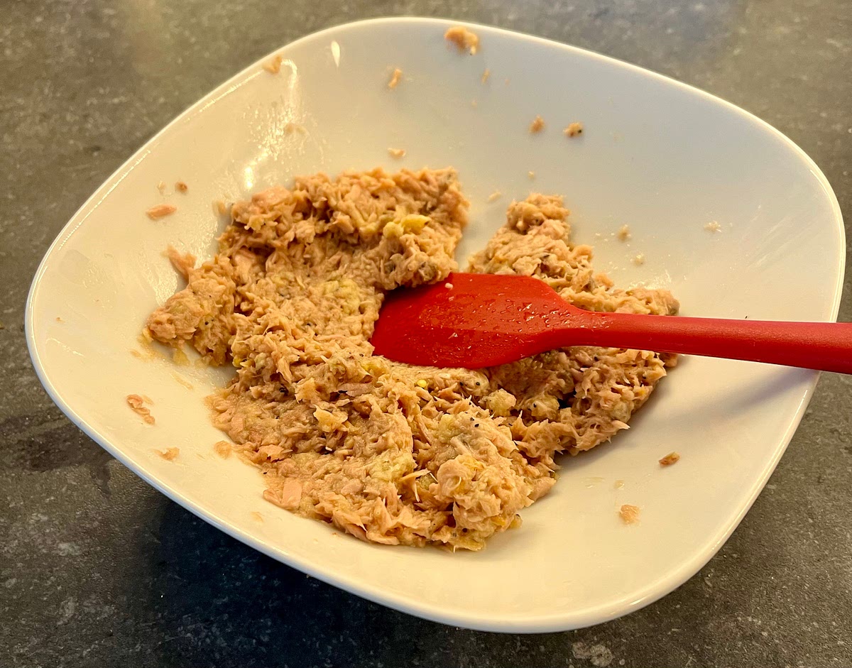 In a medium size bowl add the drained tuna, the egg, crumble in the bread and season with salt, pepper, msg and garlic powder. Mix and crush it all with a spatula until you get a homogeneous mix.
