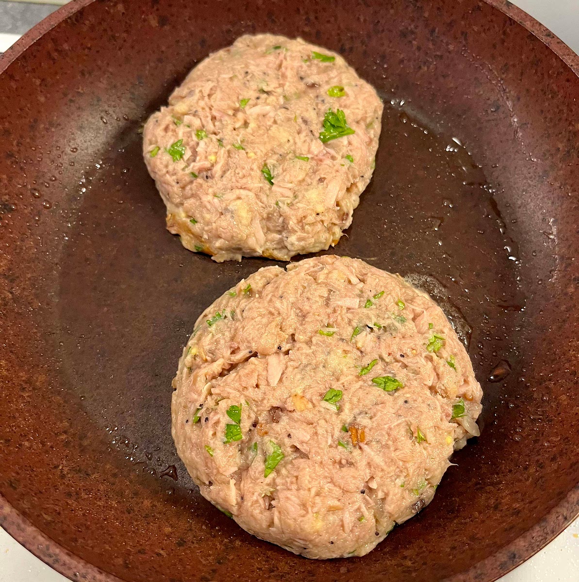 Add the canola oil to the pan, then add the meat balls, with a spatula flatten them and tidy the sides to give them a burger shape.