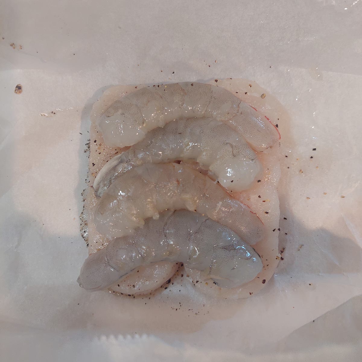 Corte 4 quadrados de papel vegetal. Coloque sobre cada quadrado uma posta de pescada, tempere com 1 pitada de sal e pimenta e distribua o miolo de camarão reservado. Feche os papelotes e coloque na Varoma, tendo o cuidado de não tapar todos os orifícios para permitir a passagem do vapor.