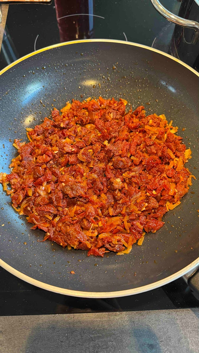 Juste avant la coloration des oignons, ajouter les tomates séchées et l’ail.