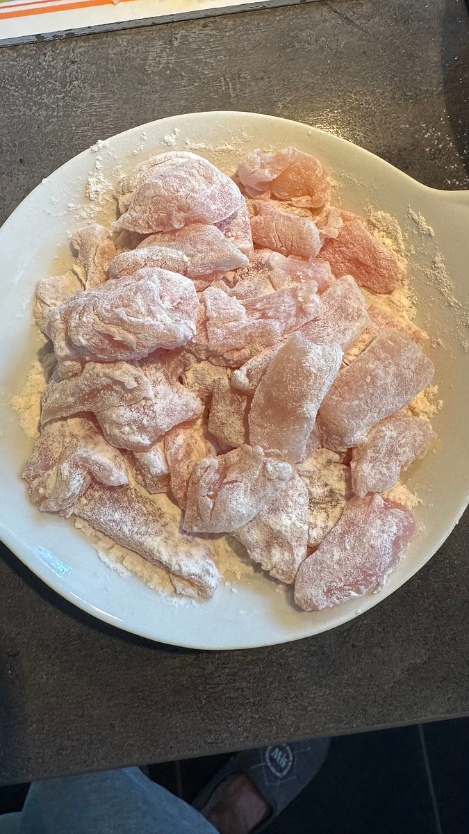 Découper les blancs de poulet en petits morceaux fins et les enrober dans la farine.