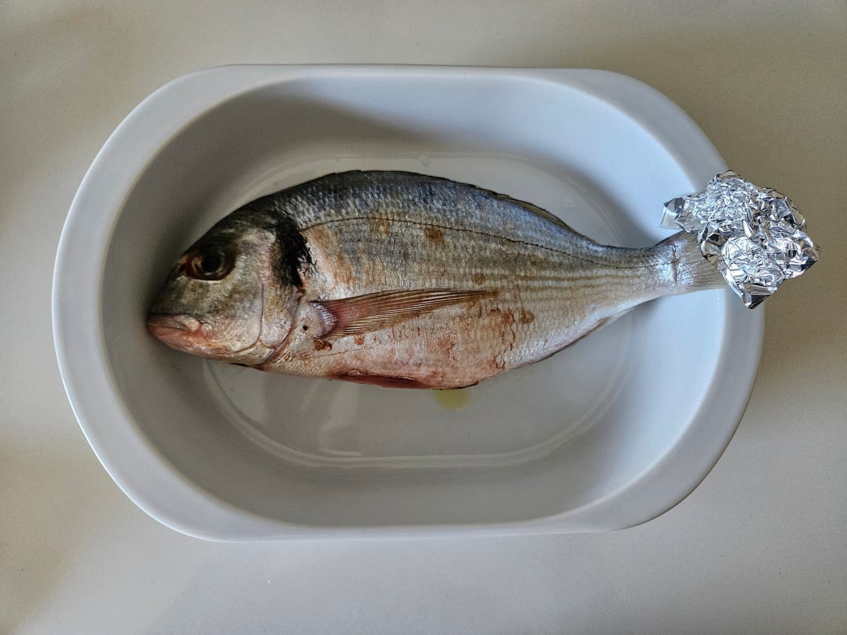 2️⃣ Mettila in una pirofila adatta al microonde e copri delicatamente la coda con un pezzetto di carta stagnola per evitare che si secchi.