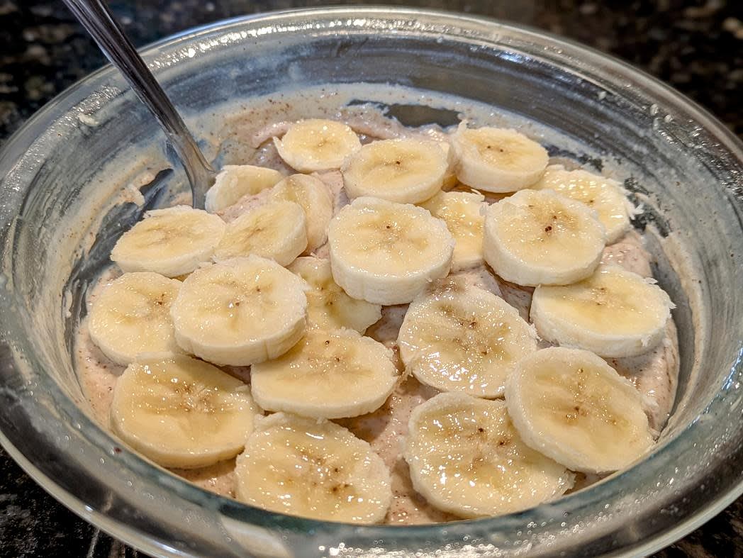 In a medium bowl or airtight container, mash one of your bananas with the back of a fork. Mix in the yogurt, nut butter, protein powder, and powdered peanut butter. Cut your other banana into slices, and add on top. Eat immediately, or cover and refrigerate overnight