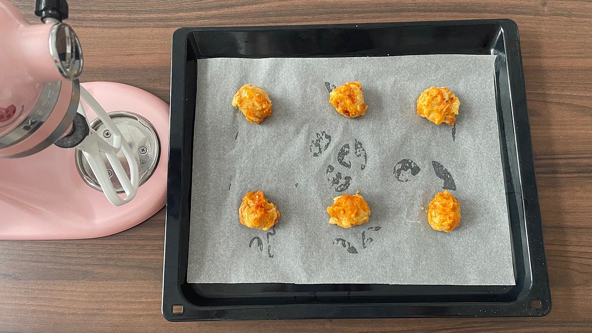 5. Portion and Bake
Using a large cookie scoop or spoon, portion the dough into 12 equal balls (approx. 50g each) and place them well spaced apart on the prepared baking trays. Bake for 13-15 minutes, or until the cookies are golden at the edges with soft, crackled centers. If using two trays at once, rotate them halfway through for even baking.