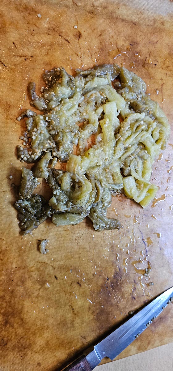 Aspettare che si intiepidisca, tagliare le estremità, sbucciarla e ridurla in purea schiacciandola con una forchetta. Aggiungere la purea di melanzane e le spezie. Se la massa risulta troppo densa, aggiungere mezzo bicchiere d'acqua (io non ho dovuto farlo). Lasciar cuocere per ulteriori 5 minuti a fuoco medio.
Aggiungere il succo di limone e il prezzemolo e dare una bella mescolata. Servire.