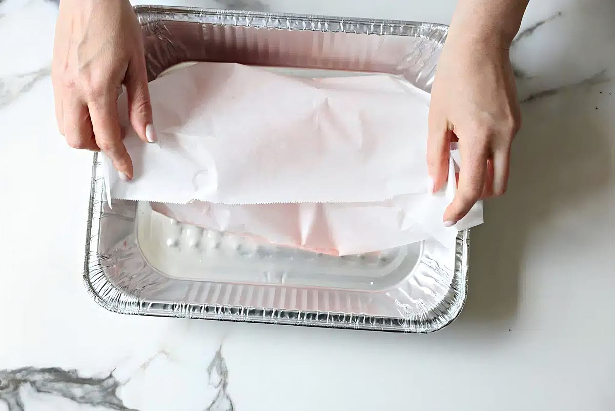 Preheat oven to 400℉. Place the salmon in a parchment-lined 9 x 13-inch pan. Sprinkle with salt and pepper and smear with the olive oil. Cover the salmon with parchment paper and then with silver foil. This method will “poach” the fish.