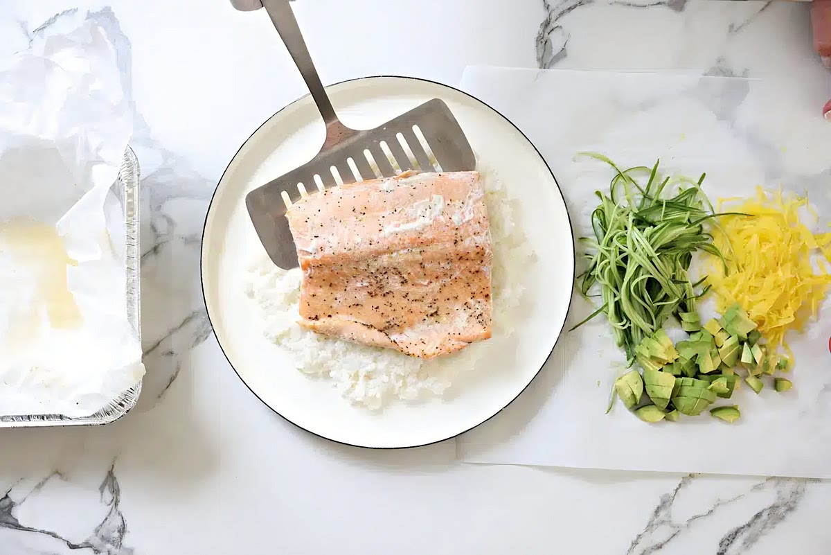To assemble, place the sushi rice on a platter. Top with the cooked salmon, using a wide spatula or fish spatula to help you transfer the salmon from the baking pan to the platter.