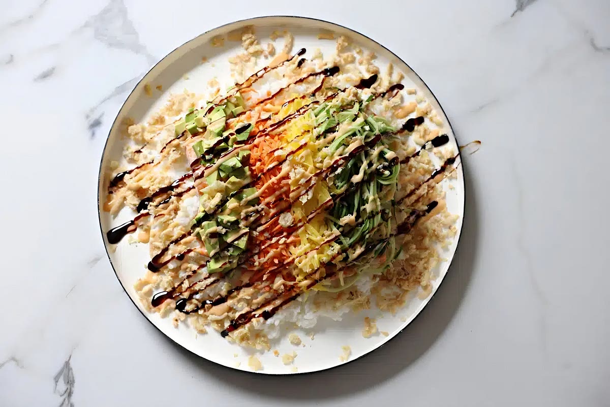 Top with cucumber, mango, carrot and avocado. Sprinkle with the onions and then drizzle the sauces to your liking.