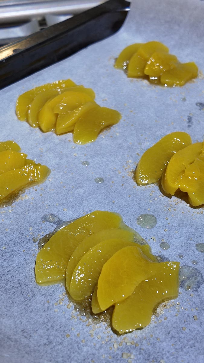 Lay peach slices neatly over the sugar.