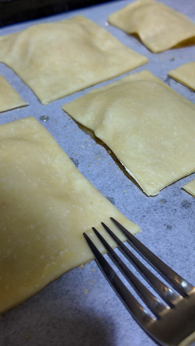 Place on top, trim edges, and seal gently with a fork.