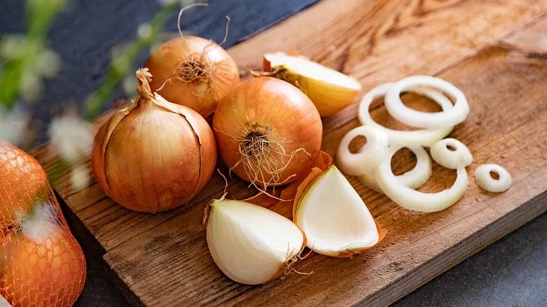 Cut the onions in half and put them in a bowl with cold water.