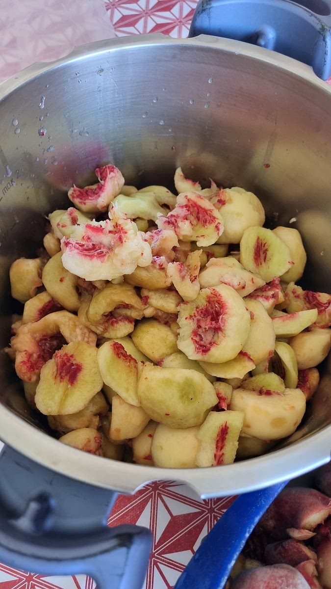 Épluchez les pêches et retirer le noyau. Mettre dans l'autocuiseur.