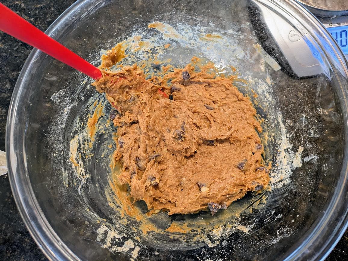 In a large bowl, mash your bananas with the back of a fork. Mix in the vanilla extract and powdered peanut butter with a silicone spatula. Fold in the chocolate chips