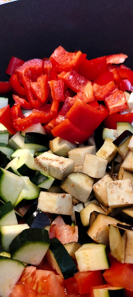 Aggiungere prima le melanzane, poi le patate e i peperoni e infine le zucchine e i pomodori aspettando tra un ingrediente e l'altro 2 minuti