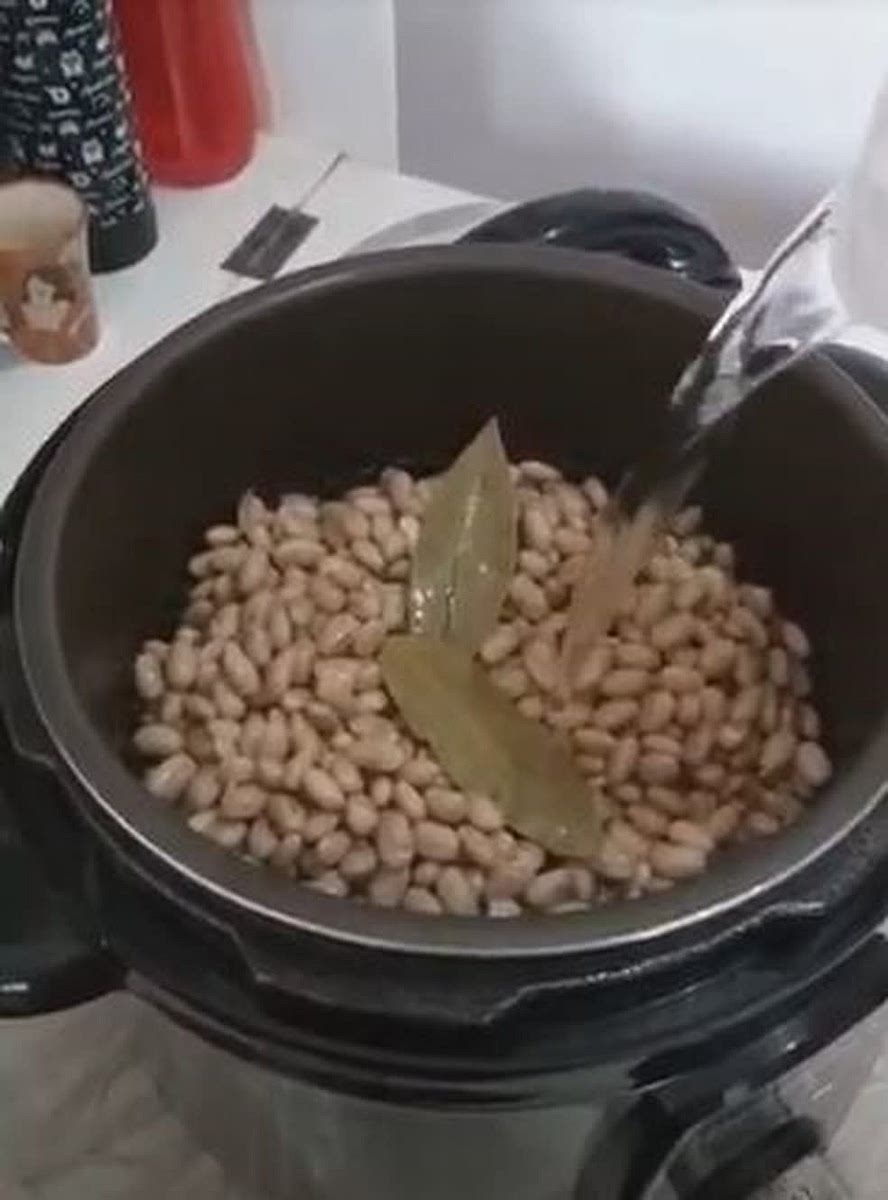 Na mesma panela, combine feijão, 4 xícaras de água e a folha de louro. Leve a ferver em alta temperatura.