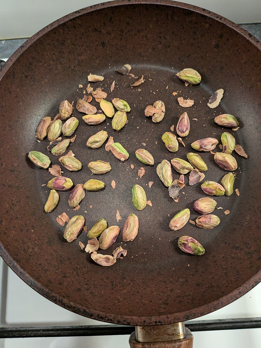 While the courgette cook, add all the pistachio kernels to a dry non-stick frying pan, and toast at medium heat moving them regularly so they toast evenly and don't burn. Toast them until fragrant and slightly golden (about 4 to 5 minutes). Once done, take them off the pan and let them cool down.