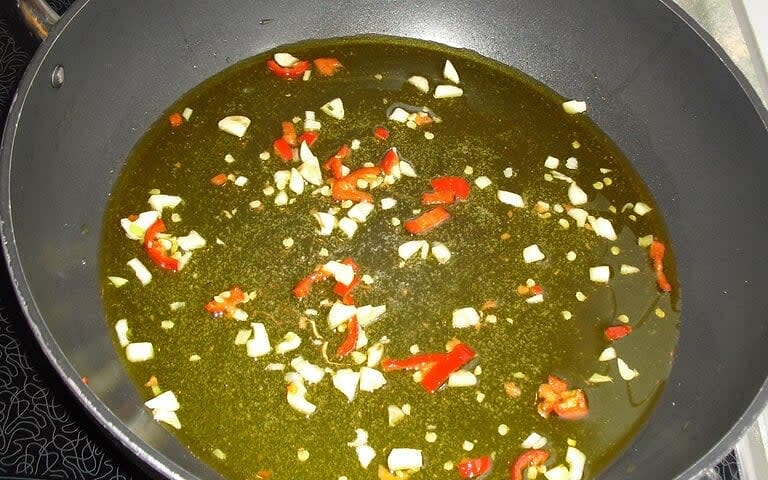 Olivenöl in großer Pfanne erhitzen. Knoblauch und Chili glasig anschwitzen. Tintenfisch und Oktopus zugeben, 2-3 Minuten anbraten.