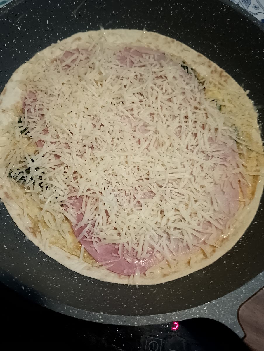 Ajouter le wrap puis retourner l'omelette dans la poêle et y déposer la tranche de jambon puis le gruyère râpé laisser quelques minutes à couvert pour que le fromage fonde.
