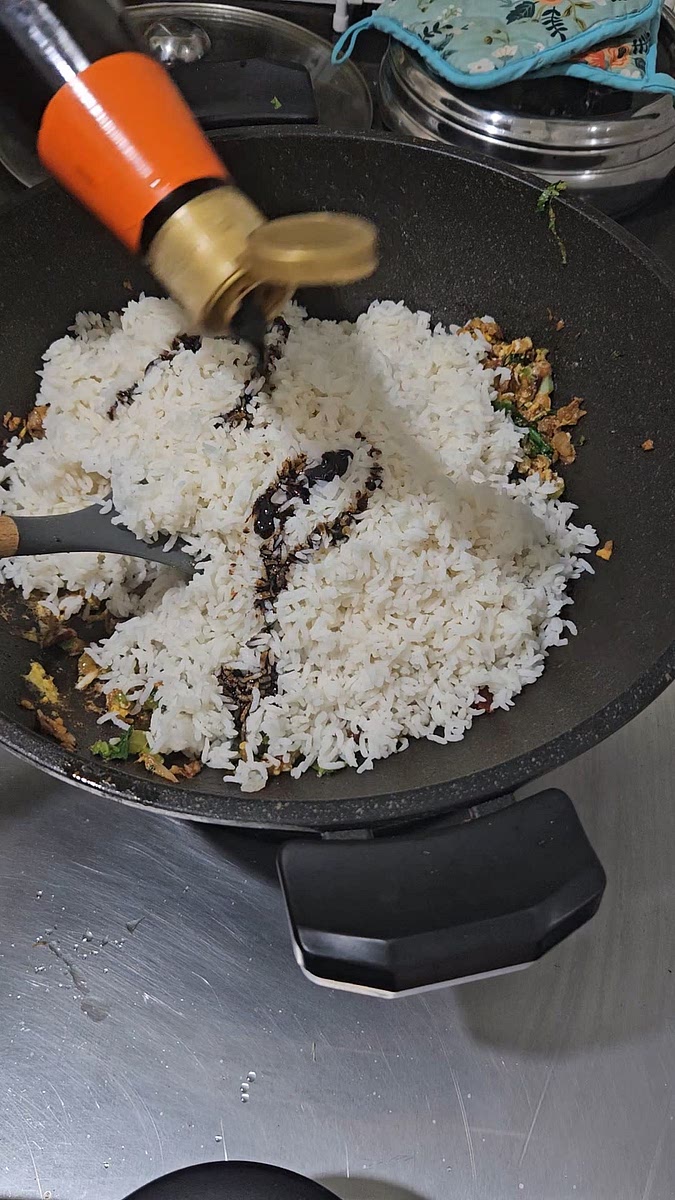 Add in 2 cups of cooked or overnight rice and black soy sauce. Mix well and Dish out.