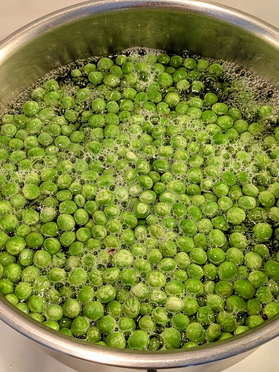 Cook the peas in boiling water for 7 minutes, then drain them with a large sieve, and pass them under a tap of cold water to cool them down.