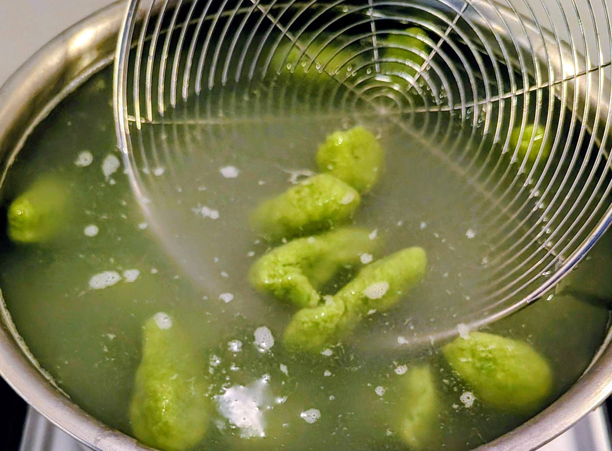 Cook the gnocchi in salted boiling water. Fish them out as they come afloat, putting them on a large non-stick frying pan. Keep the cooking water.