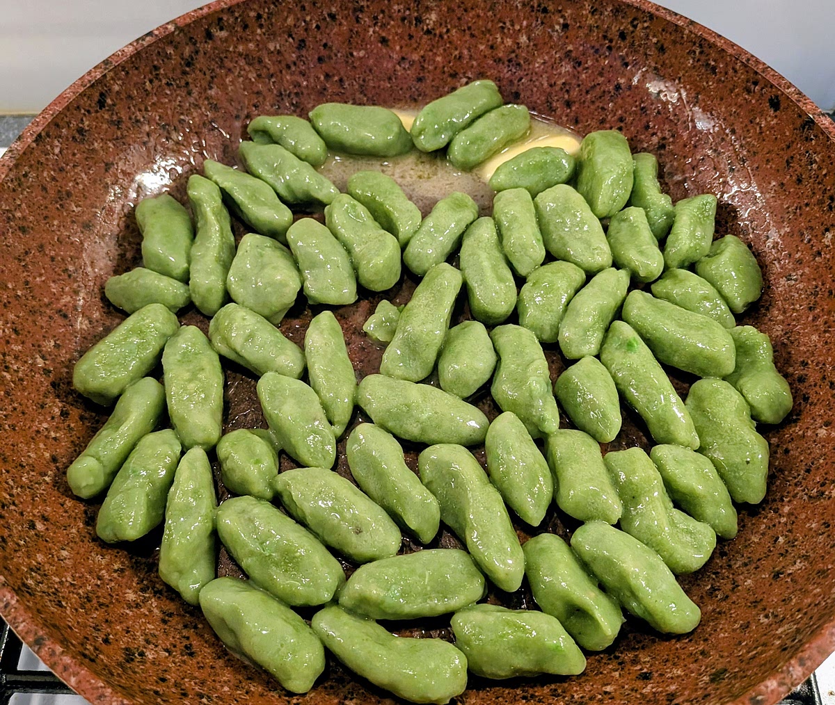 Add 5 tbsp of the cooking water and the butter to the frying pan, set the heat to medium and quickly toss the gnocchi to coat them in the butter/water emulsion.