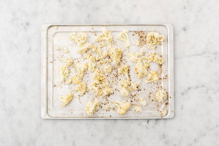 While the sweetcorn chars, pop the cauliflower onto a baking tray. Drizzle with oil, sprinkle over the Central American style spice mix, season with salt and pepper, then toss to coat. Spread the florets out in a single layer. Roast on the middle shelf until golden brown and tender, 15-20 mins. Turn halfway through.