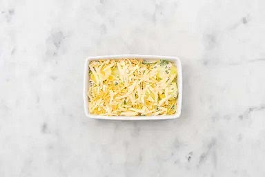 Nach der Garzeit Kartoffeln durch ein Sieb abgießen und in eine Auflaufform geben.Mit Sahne-Mix übergießen und mit Käse bestreuen. In den letzten 15 Minuten der Karotten-Backzeit Auflaufform neben die Karotten in den Ofen geben und mitbacken.