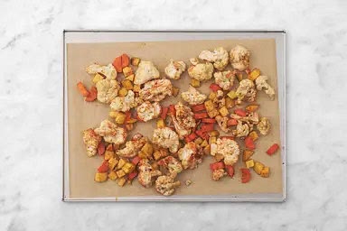 Blumenkohl, Karotte und Kartoffelwürfel auf ein mit Backpapier belegtes Backblech geben und mit „Hello Paprika“, Kumin, 2 EL [3 EL | 4 EL] Öl, Salz und Pfeffer* vermengen. Gemüse im Ofen in 18 – 22 Min. goldbraun backen.