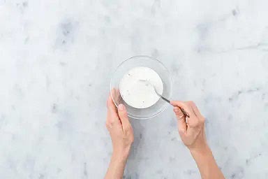 In einer kleinen Schüssel Joghurt und Knoblauch-Dressing mit Salz, Pfeffer und Essig* vermengen.