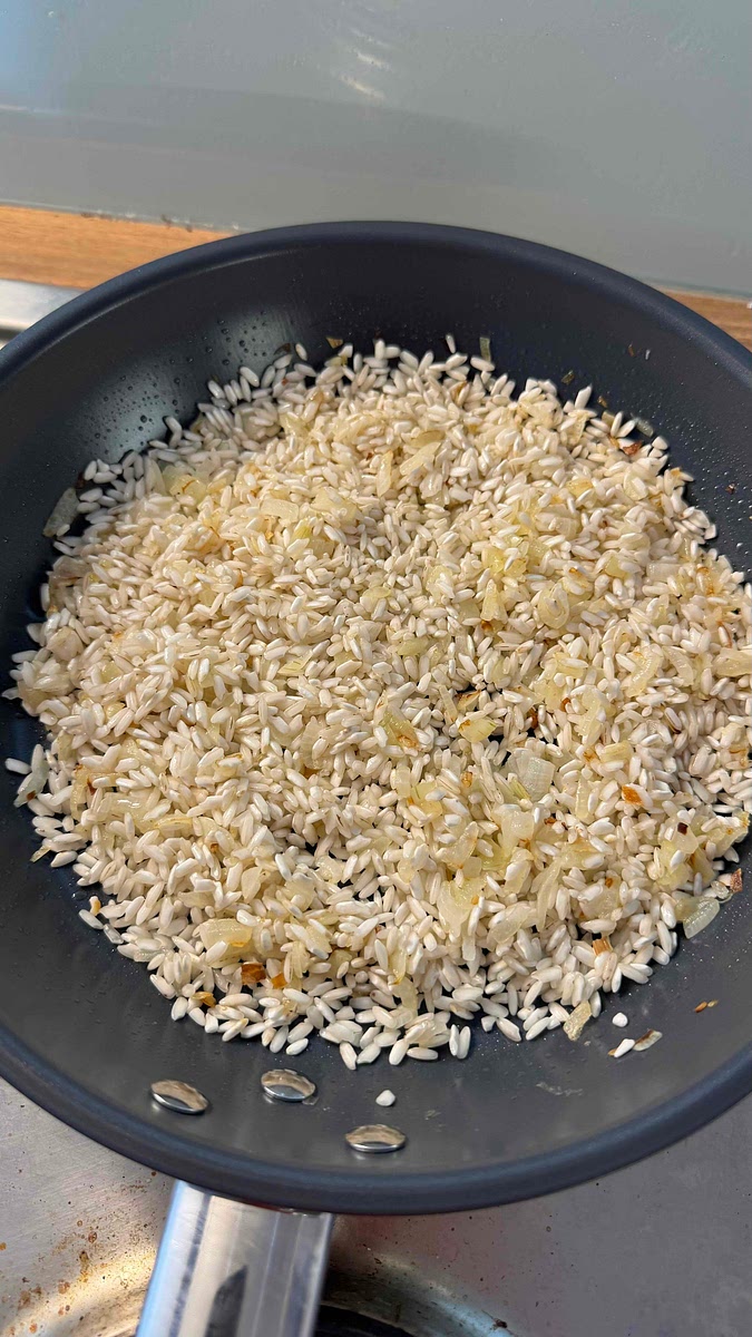 Faire nacrer le riz pendant 2-3 minutes en le plaçant dans la poêle avec l’oignon et mélanger.