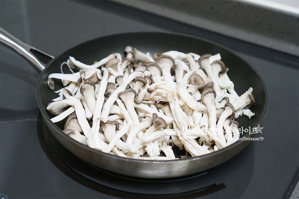 마른 팬에 느타리를 넣고 익혀줍니다. 센 불에서는 겉이 타기 쉬우니 중약불에서 익혀 주었어요. 느타리버섯무침을 만들 때 물에 데쳐서 만들기도 하는데, 간단한 팁을 드리자면 이렇게 버섯에서 나오는 수분으로 익혀주면 그 향이 더 진하고 식감이 더 쫄깃해 맛있어요. 먹기 좋게 익으면 그릇에 옮겨 담아줍니다.