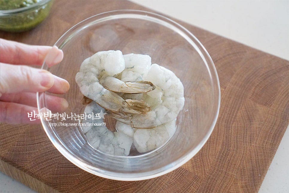 손질된 냉동새우를 준비한 뒤 찬물에 담가 해 동해주었습니다. 탱글한 식감과 감칠맛 나는 새우는 바질페스토와 잘 어울리는데요. 그 외 베이컨이나 버섯, 조개류 등을 넣어도 좋습니다. 양파는 밥알의 식감과 어우러질 수 있게 잘게 다져 썰어 준비해 줍니다. 마늘도 다져주었습니다.