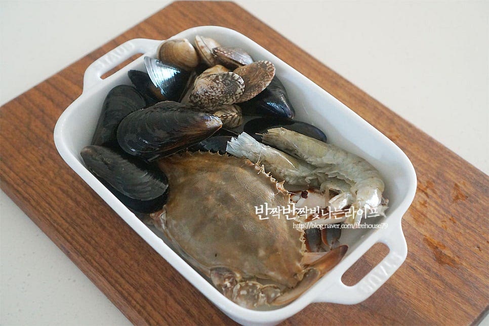 냉동 해산물을 준비했어요. 손질된 바지락과 홍합이라 따로 해감 손질 없이 씻어주었어요. 손질되지 않았다면 소금물에 해감하여 준비해 주세요. 새우는 수염과 앞다리, 물총 주머니 입과 뿔의 뾰족한 부분을 잘라내어 줍니다. 냉동 꽃게는 흐르는 물에 씻은 뒤 게딱지를 분리하여 아가미를 제거하고 먹기 좋게 4등분 하여 주었어요. 크기에 따라 먹기 좋게 잘라주세요. 대파와 고추는 송송 썰어줍니다. 냉장고 사정에 따라 양파, 당근, 콩나물 등을 채소를 푸짐하게 넣으셔도 좋아요.