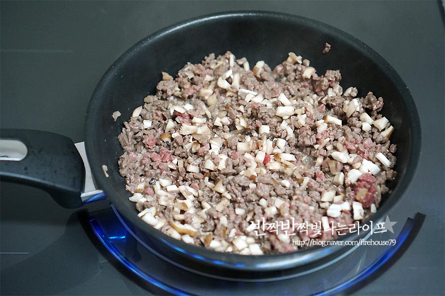 밑간 한 소고기를 달군 팬에 볶다가 표고버섯을 넣고 같이 볶아주세요. 버섯과 볶다 보면 수분이 나오는데 고기랑 버섯을 바싹 볶아 수분을 날려주세요.