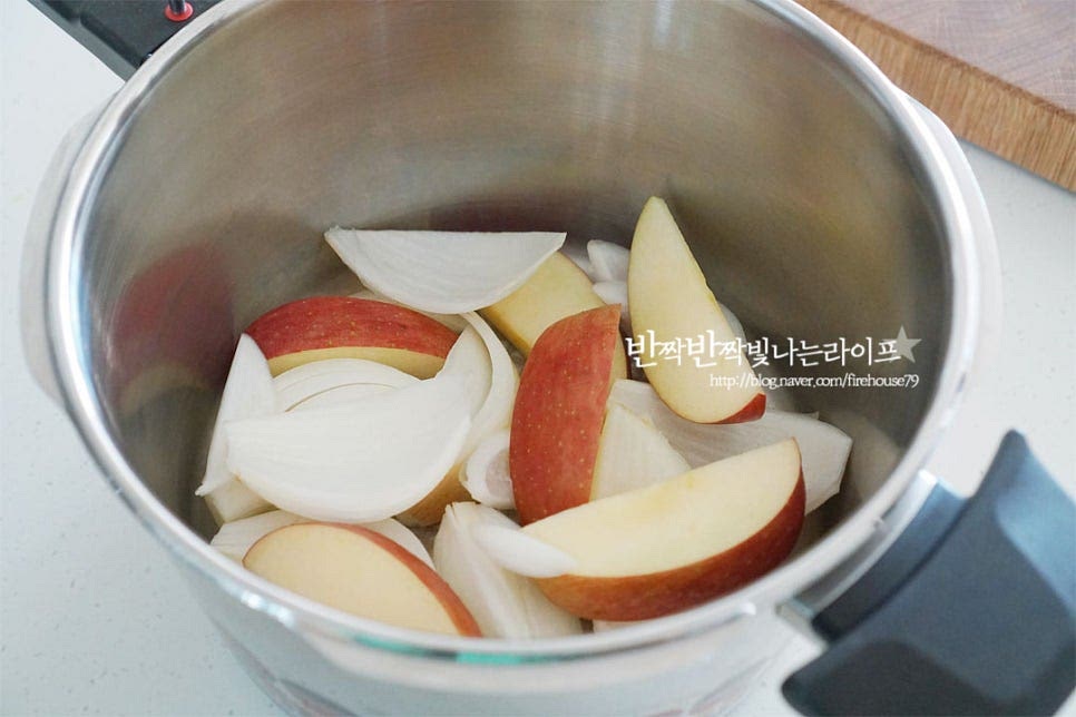 용량이 큰 압력솥을 준비한 뒤 먼저 사과와 양파를 깔아줍니다. 앞다리살의 육질을 부드럽게 해주면서 달콤한 감칠맛을 살려주는 역할을 해준답니다. 그 위로 된장을 바른 돼지 앞다리살을 올려줍니다. 된장을 물에 풀어서 넣어도 되지만 겉면에 발라주면 적당하게 간도 스며들어요. 향신 재료들도 함께 넣어주는데요. 통마늘, 생강, 월계수잎, 통후추를 넣어줍니다. 생강은 향이 강해 마늘 한두 알 크기로 넣어주고, 마늘은 조금 넉넉하게 주셔도 좋습니다. 그 위로 대파를 올려 덮어줍니다. 재료들 사이로 넣고 앞다리살 수육을 삶으면 촉촉하게 부드럽게 익어요. 생강술(청주) 1/2컵, 물 1컵 인스턴트 블랙커피 미니 1봉을 넣어줍니다. 압력솥 수육 삶기를 할 때는 조리시간이 짧기도 하고 저수분 요리가 가능합니다. 재료를 모두 넣고 삶아주면 되어 간단해요.