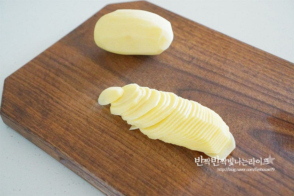 감자는 껍질을 깎은 뒤 얇고 일정한 두께로 슬라이스해줍니다. 칼로 썰어주었는데 간편하게 도구를 활용해도 좋아요. 가볍게 물에 흔들어 씻어 전분기를 제거하고 체에 밭쳐 물기를 털어줍니다. 감자그라탕에 베이컨과 양파를 더해주었는데요. 달큰하고 짭조름한 풍미가 잘 어울린답니다. 두 가지 모두 채 썰어 줍니다.