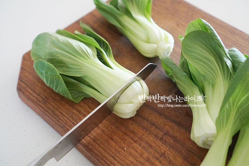 청경채는 밑동 부분을 잘라내어 줍니다. 밑동 부분에 흙이 많이 묻어나기 때문에 식초물에 담가 살살 흔들어준 뒤 흐르는 물에 헹구어 물기를 털어줍니다. 손질한 채소는 데친 뒤 무침 만들어 줄 것이랍니다. 먼저 잠길 정도로 물을 붓고 보글보글 끓어오르면 소금 1 작은 술 넣어줍니다. 초록잎 채소는 데칠 때 소금을 약간 넣어주셔야 녹색이 더 선명하게 익어요. 두께가 있는 줄기 부분 먼저 끓는 물에 넣고 전체적으로 넣어 데쳐줍니다. 잎 부분에 비해 줄기가 두꺼우므로 먼저 익혀주시면 고르게 익어요. 오래 데칠 필요 없이 숨이 죽으면 바로 건져내어 차가운 물에 헹구어 줍니다. 물기를 꼭 짜준 뒤 길이에 따라 2~3등분해 주셔도 좋아요.