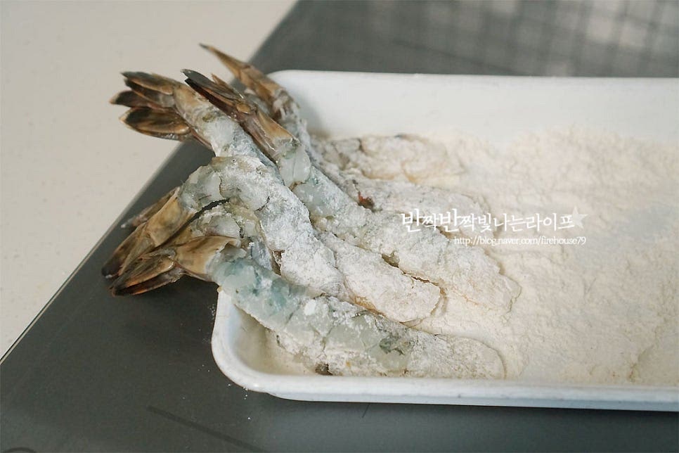 반죽이 겉돌지 않도록 먼저 튀김가루를 가볍게 묻혀 털어내어 줍니다. 그리고 꼬리 부분을 잡고 반죽을 입혀주시면 됩니다. 웍에 적당량의 식용유를 붓고 160도로 달구어 줍니다. 반죽을 떨어뜨려 보았을 때 지글지글 떠오르는 정도면 됩니다. 꼬리를 잡고 하나씩 넣고 튀겨줍니다. 서로 붙지 않도록 꼬리 부분을 잡고 살살 흔들어 튀겨주었어요. 노릇하게 튀겨지면 채망에 올려 기름을 빼줍니다. 공기가 통할 수 있는 망에 올려주면 내내 식감이 바삭하고 기름도 더 잘 빠져요. 갓 튀긴 그 맛은 정말 최고죠. 튀겼을 때 맛이 없는 게 없다지만 새우요리 중에서 단연 손꼽히는 맛인 것 같아요~ 바삭바삭 식감부터 맛깔나요. 영상도 같이 담았어요. 새우튀김 바삭바삭 만들기 튀김반죽옷 얇고 바사삭하게 입혀 고소함과 탱글함을 동시에 맛보세요. 맛있게 만들어 드세요^^ 끄읕 !