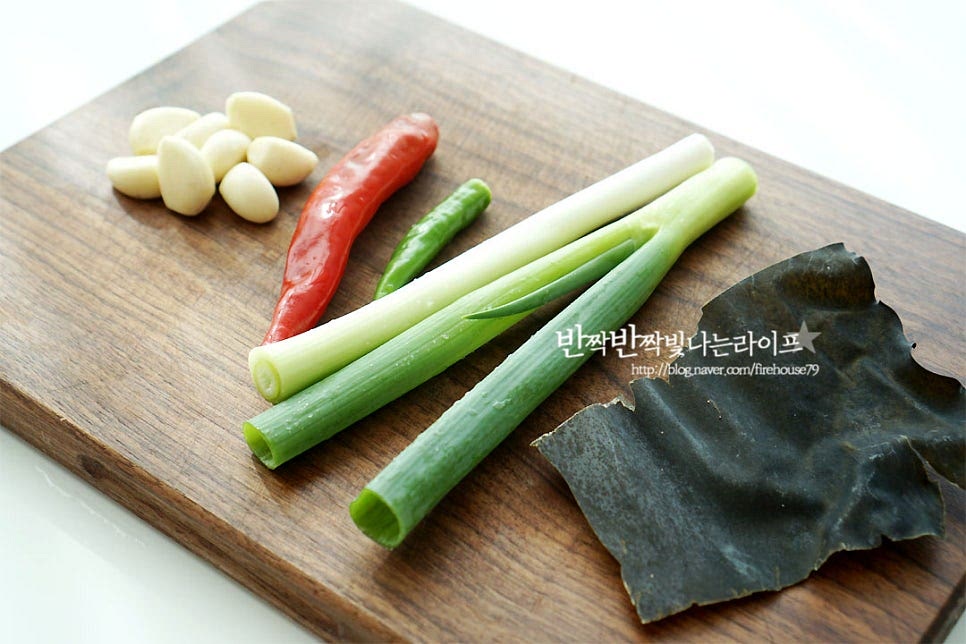 국물 맛을 더해주는 재료로 마늘, 고추, 대파, 다시마를 준비했어요. 마늘은 편으로 썰고 대파는 송송, 고추는 어슷하게 썰어줍니다. 대파 대신 쪽파나 실파도 좋아요. 마늘은 깔끔한 국물 맛을 내기 위해 편으로 썰어주었는데 다진 마늘을 넣으셔도 됩니다.