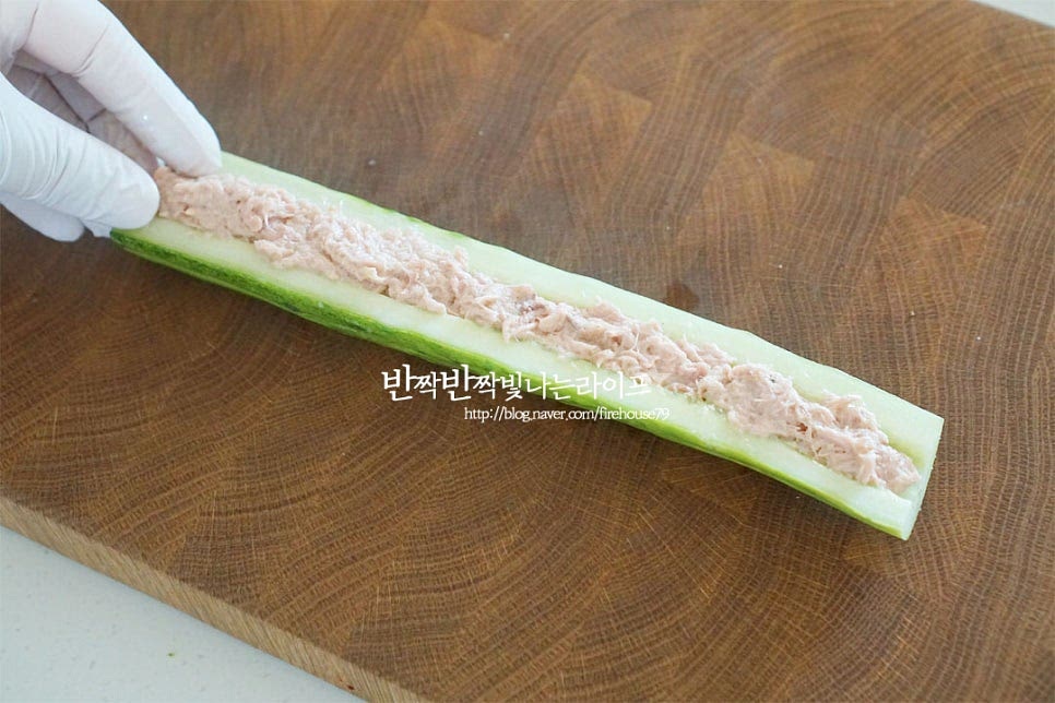 반으로 자른 오이 속에 참치마요를 넣어 채워줍니다. 그리고 나머지 반쪽을 덮어 둥근 기둥 모양을 만들어줍니다. 씨를 제거한 속에 참치로 채워준답니다.