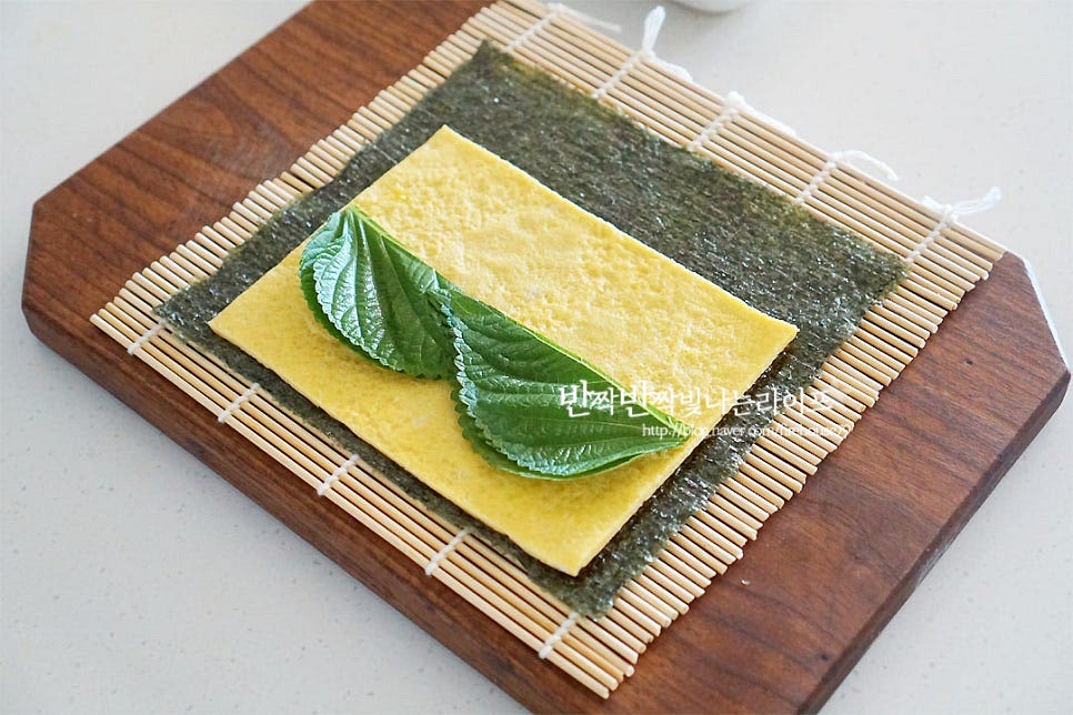 김을 깔고 넓게 썰어둔 달걀을 먼저 올린 뒤 깻잎을 4장 올려줍니다. 그 위로 당근, 맛살, 단무지를 올려줍니다. 그 위로 계란을 듬뿍 올려줍니다. 재료를 감싸듯이 모양을 잡아주어요. 돌돌 말아 동그란 모양을 잡아주고 끝부분은 참기름 또는 물을 묻혀 고정하여 줍니다. 바로 썰지 않고 이음새 부분이 아래로 향하게 놓고 5분 정도 두어 고정한 뒤 썰어주시면 되어요. 고소하게 참기름은 전체적으로 발라주고요~ 먹기 좋게 썰어줍니다. 밥이 들어가지 않은 저탄고지의 맛 간단한 재료로 만들었는데 고소한 맛이 가득해서 맛있어요. 영상도 같이 담았어요. 식단 조절하는 신랑에게 소고기, 닭 가슴살 등 넣고 만들어 주곤 하는데 다이어트김밥이 어쩜 맛있냐고 자꾸만 손이 간다 더라고요. 가장 매력은 속 재료를 다채롭게 넣어 만들 수 있어 질리지 않고 색다르게 맛볼 수 있다는 점 같아요. 키토김밥 밥 없이도 든든하게 챙겨드세요^^ 끄읕 !