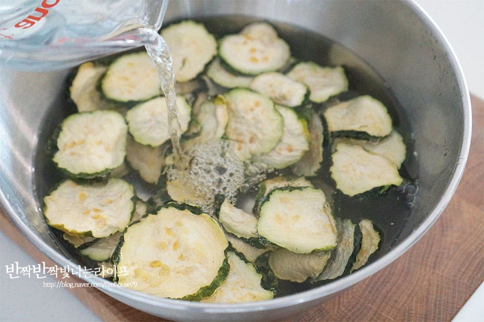 보통 가을에 말린 묵은 나물을 겨우내 볶음 반찬으로 만들어 먹곤 하는데요. 말린 것이라 만져보면 단단합니다. 요리하기에 앞서 먼저 불려줍니다. 재료가 충분히 잠길 수 있도록 미지근한 물을 부어줍니다. 뜨거운 물이 아닌 만져보았을 때 따뜻한 정도의 미지근한 물에 불리면 단단하게 건조된 호박이 수분을 흡수하여 본연의 식감이 느껴지면서도 딱딱하지 않습니다. 30분 이상 불려줍니다. 건조 상태에 따라 불리는 시간을 조절하여 주고 중간에 상태를 확인하여 불리면 됩니다. 보드라운 정도에 맞게 해주고 삶거나 오래 담그면 되려 향과 맛이 날아갈 수 있어요. 미지근한 물에 30분 이상 불려 만져보니 수분을 머금으면서 오독오독 보드라워요. 가볍게 물기를 짜줍니다. 수분을 머금은 상태가 유지되도록 물은 꼭 짜지 않습니다.